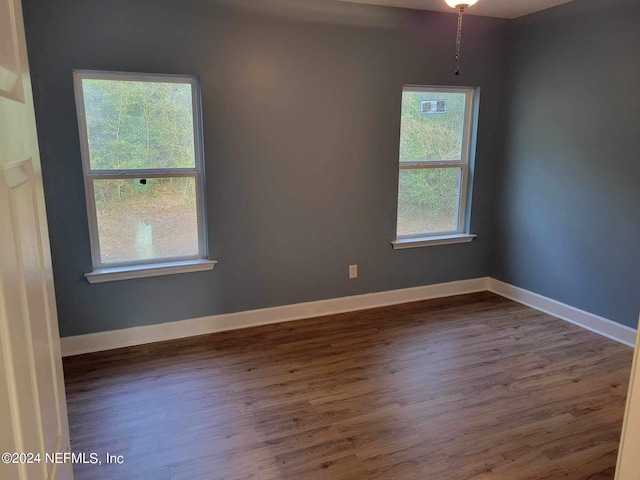 unfurnished room with wood finished floors and baseboards