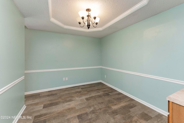 empty room featuring dark wood-type flooring, a textured ceiling, and a chandelier