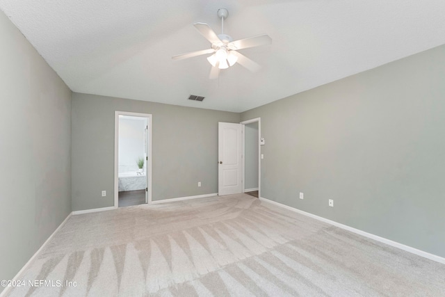 unfurnished bedroom with connected bathroom, ceiling fan, light carpet, and a textured ceiling