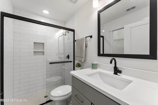 bathroom featuring toilet, vanity, and walk in shower