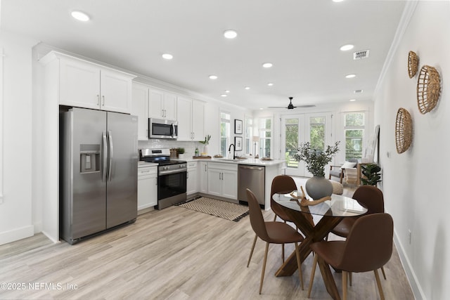 kitchen with sink, ceiling fan, light hardwood / wood-style floors, white cabinetry, and stainless steel appliances