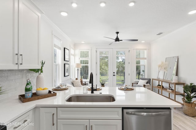 kitchen featuring white cabinetry, sink, tasteful backsplash, stainless steel dishwasher, and crown molding