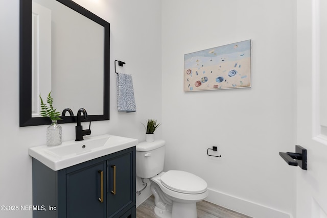 bathroom with vanity, hardwood / wood-style flooring, and toilet