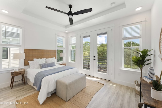 bedroom with a raised ceiling, access to exterior, ceiling fan, and french doors