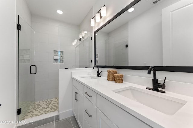 bathroom with tile patterned flooring, vanity, and walk in shower