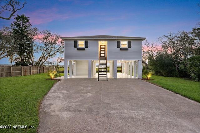 view of front of property with a carport and a lawn