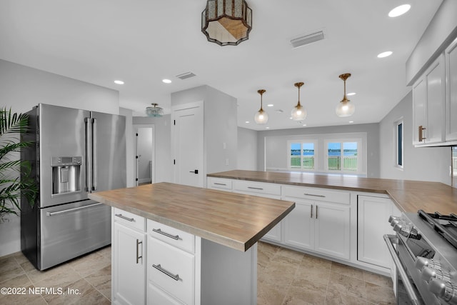 kitchen featuring wooden counters, white cabinets, and appliances with stainless steel finishes