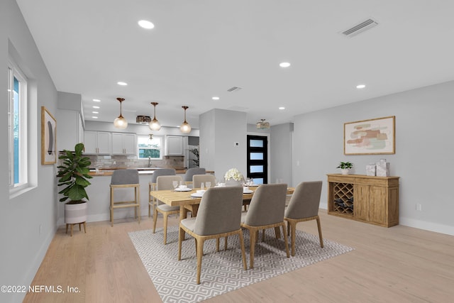 dining space with sink and light hardwood / wood-style floors