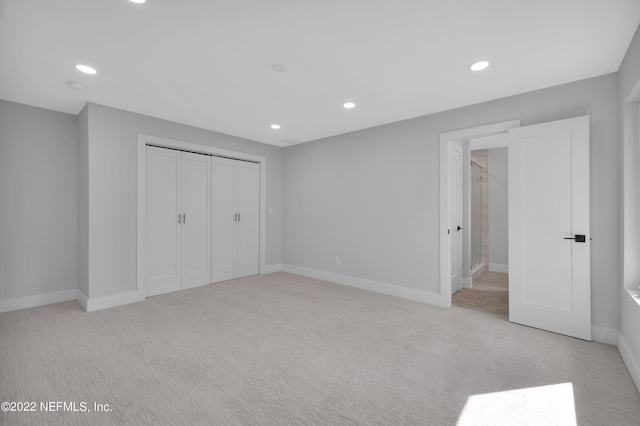 unfurnished bedroom featuring a closet and light carpet