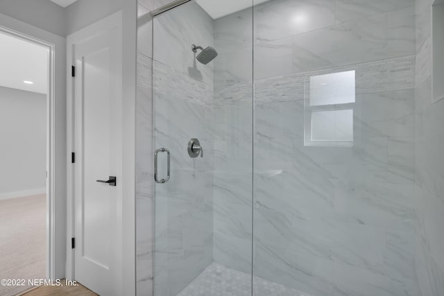 bathroom featuring a shower with door