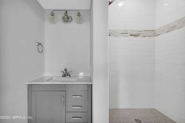 bathroom featuring tiled shower and vanity