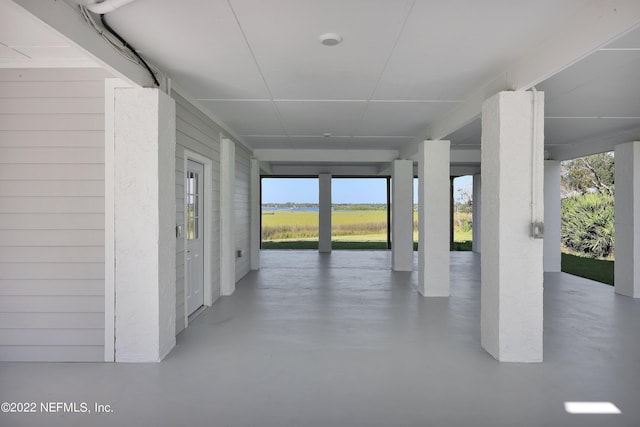 interior space featuring wooden walls and concrete flooring