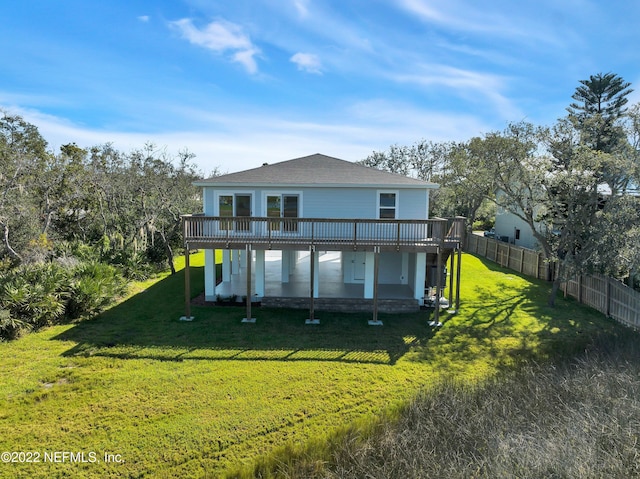 rear view of property with a yard and a wooden deck