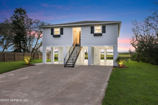 coastal home featuring a yard and a carport