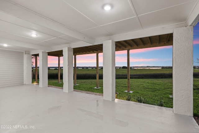 patio terrace at dusk with a rural view and a lawn