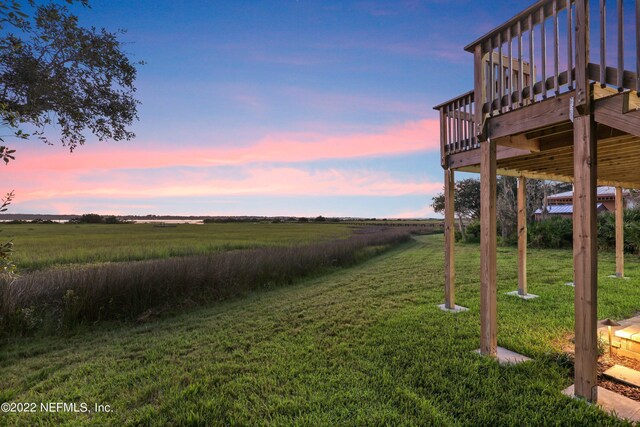 yard at dusk with a wooden deck and a rural view