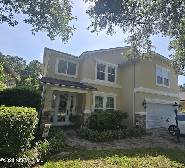 view of front of property with a garage and central AC