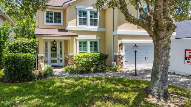 view of front of house with french doors and a front lawn