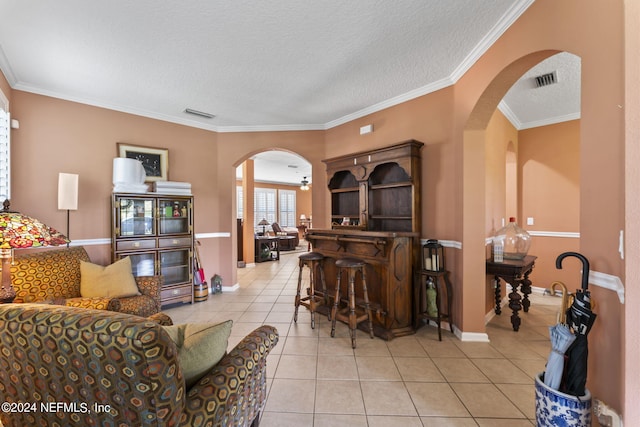 tiled living room with a textured ceiling and ornamental molding