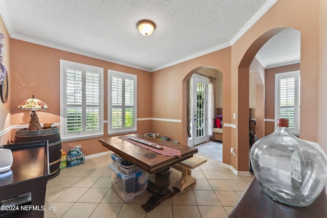 rec room featuring crown molding, light tile patterned floors, and a textured ceiling