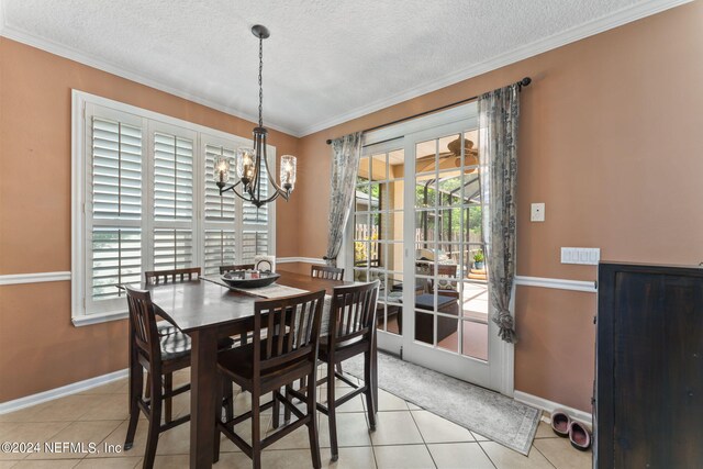 dining space featuring ornamental molding, a notable chandelier, light tile patterned flooring, and a textured ceiling