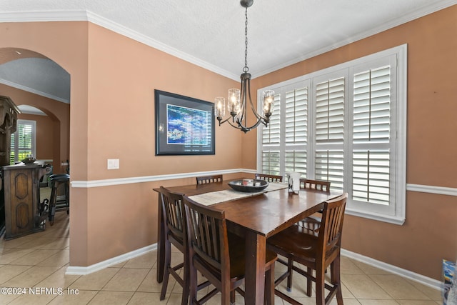 tiled dining room with a notable chandelier, a textured ceiling, and crown molding