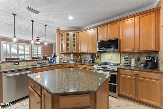 kitchen featuring stainless steel appliances, sink, a center island, and light tile patterned floors