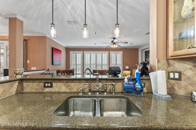 kitchen with sink, pendant lighting, decorative backsplash, and ceiling fan