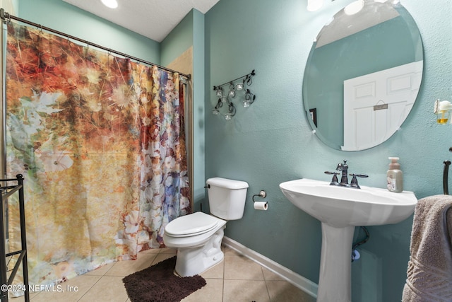 bathroom featuring tile patterned flooring, toilet, and a textured ceiling