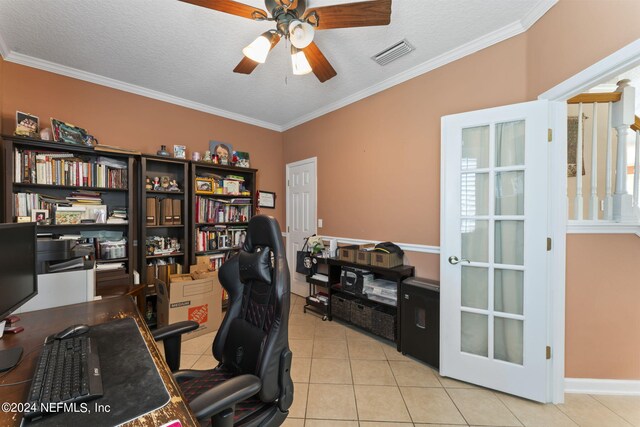 home office with a textured ceiling, light tile patterned floors, and ornamental molding