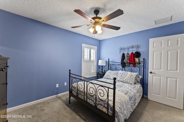 carpeted bedroom with a textured ceiling and ceiling fan