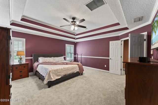 carpeted bedroom featuring crown molding, a raised ceiling, multiple windows, and ceiling fan