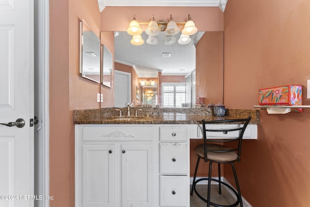 bathroom featuring vanity, a textured ceiling, and ornamental molding