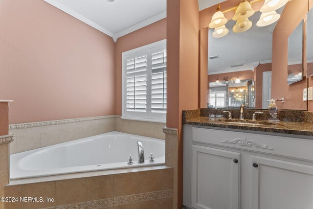 bathroom with a relaxing tiled tub, a textured ceiling, vanity, and ornamental molding