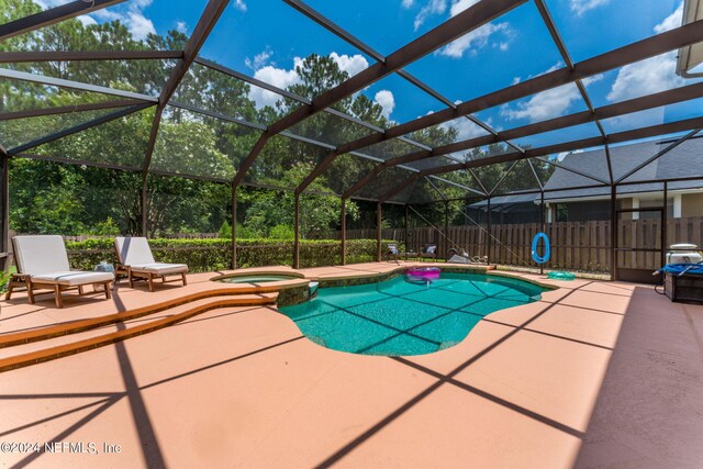 view of pool with a patio, an in ground hot tub, and glass enclosure