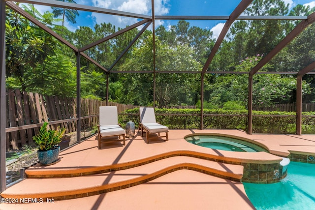 view of pool featuring an in ground hot tub, glass enclosure, and a patio area