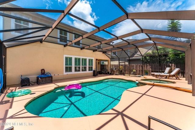 view of swimming pool with an in ground hot tub, glass enclosure, and a patio area