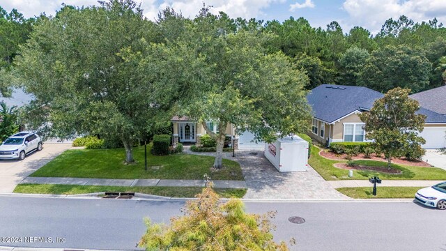 view of property hidden behind natural elements featuring a front yard