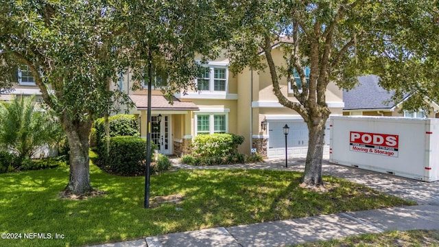 view of front of house featuring a garage and a front lawn