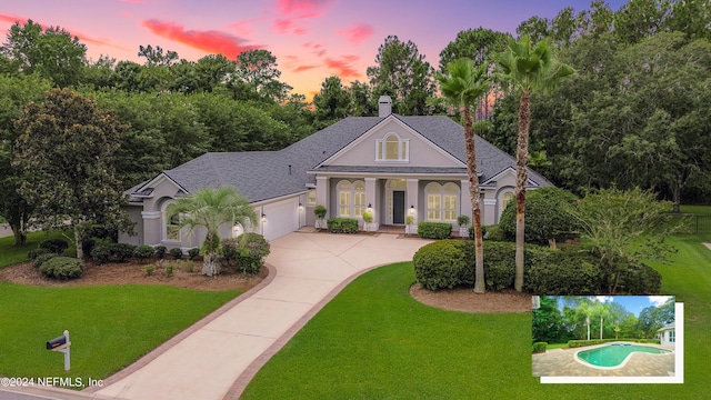 view of front of property featuring a lawn and a garage