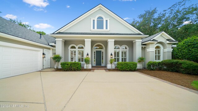 greek revival inspired property with a garage