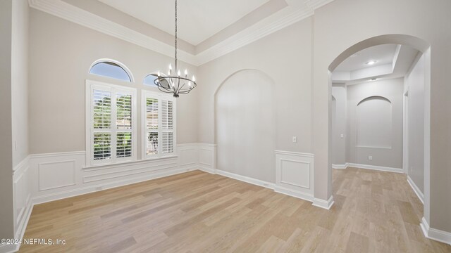 spare room with light hardwood / wood-style flooring and a chandelier