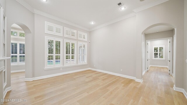 spare room featuring light hardwood / wood-style floors and crown molding