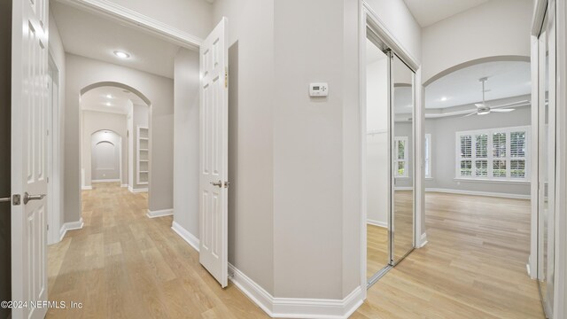 hall with light wood-type flooring and a barn door