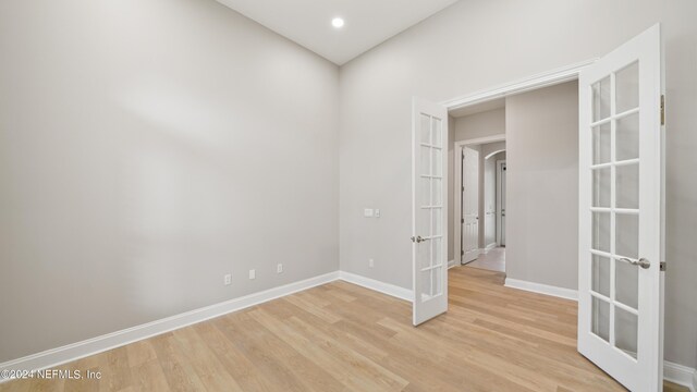 empty room with french doors and light hardwood / wood-style flooring