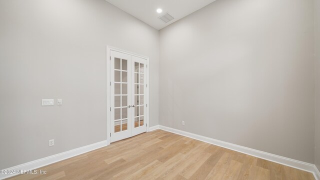 unfurnished room featuring light hardwood / wood-style floors and french doors