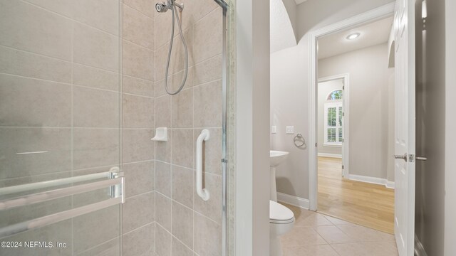 bathroom with tile patterned flooring, toilet, and walk in shower