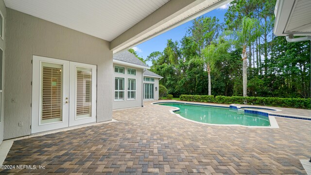 view of pool featuring an in ground hot tub, french doors, and a patio