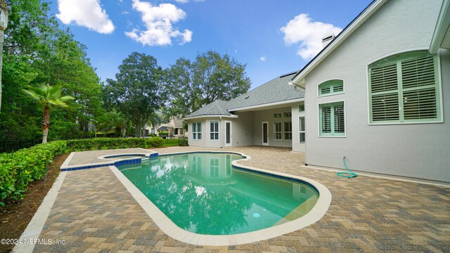 view of swimming pool with an in ground hot tub and a patio