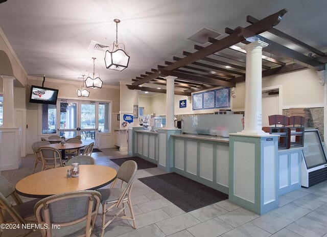 kitchen featuring decorative columns, kitchen peninsula, light tile patterned flooring, and pendant lighting